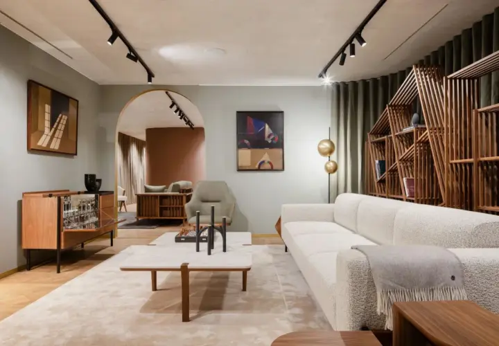 Salon lumineux avec canapé blanc, étagère en bois design et tableau abstrait. Une ambiance de deco maison moderne chic.