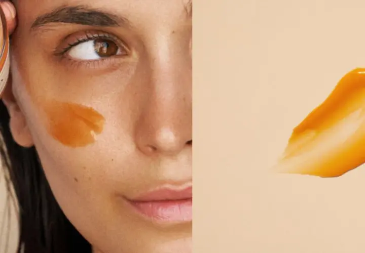 Un masque visage orangé appliqué sur la joue d'une femme. La question est : combien de temps garder un masque visage pour un soin optimal ?