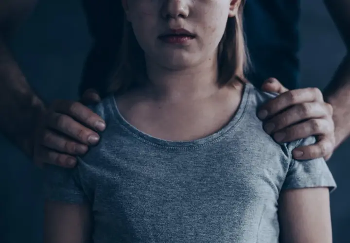 Dziecko z rękami na ramionach. Czy socjopata kocha swoje dzieci? Pytanie pozostaje otwarte, gdy patrzymy na tę scenę.