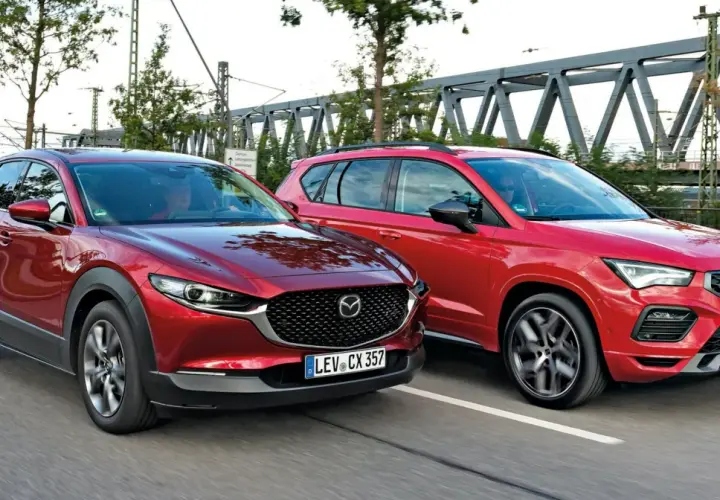 Dwa czerwone SUV-y jadące obok siebie. Po lewej Mazda CX-30, po prawej Seat Ateca. Porównanie mazda cx 30 wymiary.