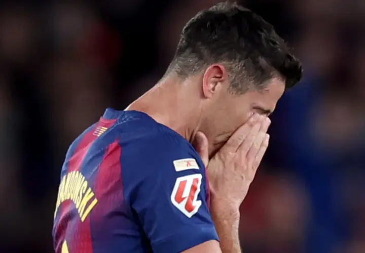 Piłkarz Robert Lewandowski z twarzą ukrytą w dłoniach, smutny po przegranym meczu, być może symbolizującym koniec kariery.