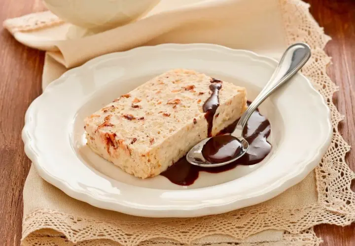 Delizioso semifreddo alla mandorla con salsa al cioccolato su un piatto bianco, pronto per essere gustato.