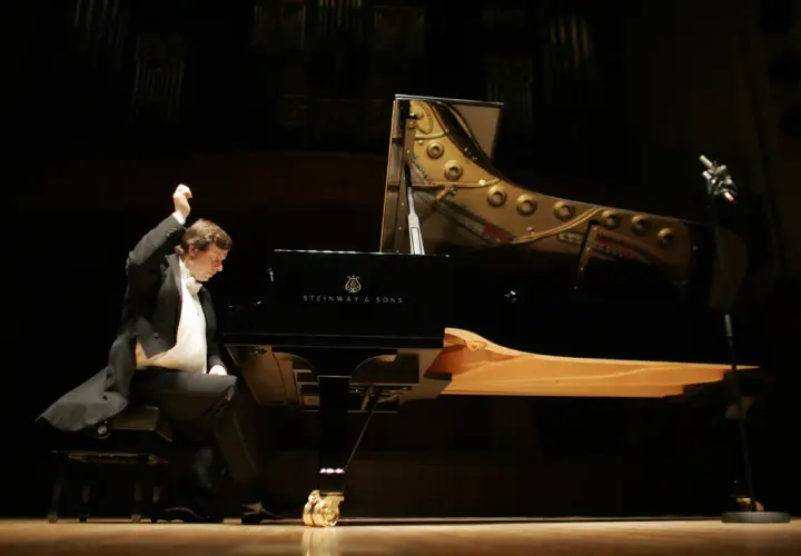 Krzysztof Jabłoński, pianista, w akcie tworzenia muzyki przy fortepianie Steinway. Data urodzenia artysty nie jest widoczna.