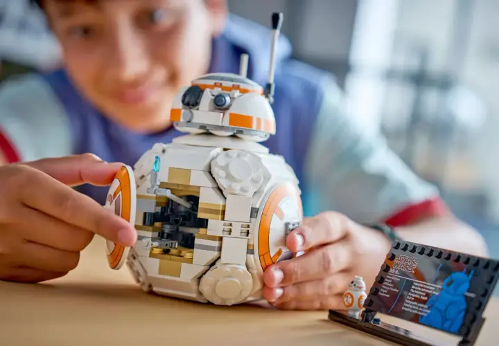 Chłopiec składa największy zestaw LEGO Star Wars - droida BB-8. Obok stoi mniejsza figurka.