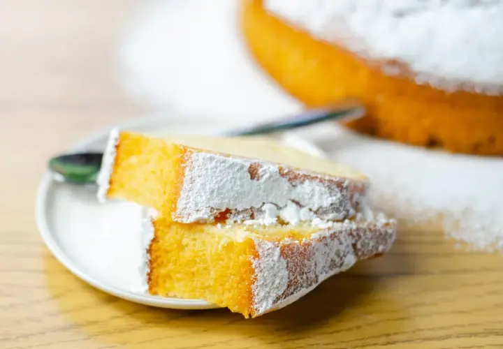 Due fette di torta soffice e dorata, spolverate di zucchero a velo, perfette per preparare torte golose facili.
