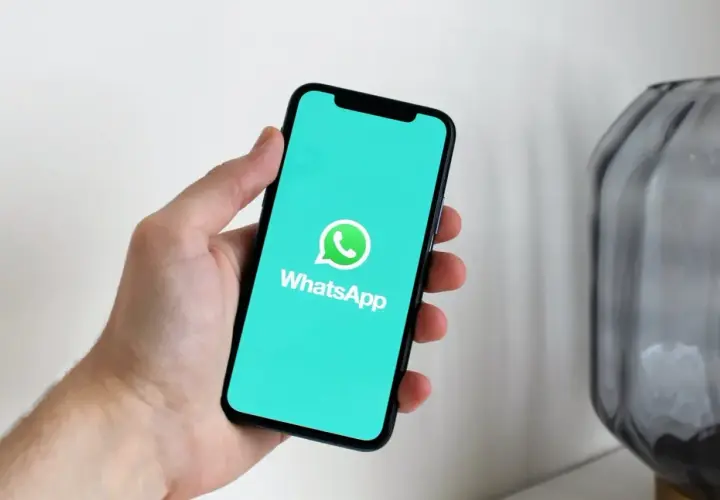 Dłoń trzyma smartfon z logo WhatsApp. Aplikacja istnieje od 2009 roku, więc ma już swoje lata!