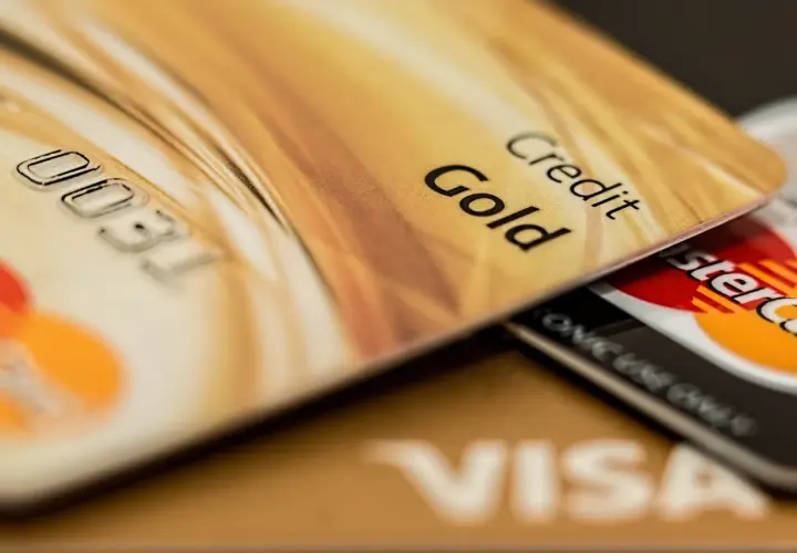 Cartes de crédit dorées, dont une "Gold", superposées. Pensez aux frais bancaires au Portugal pour ces paiements.