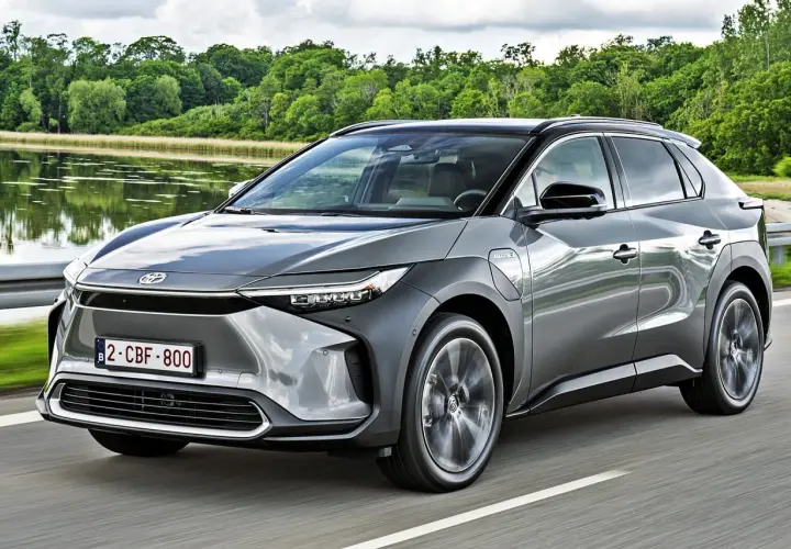 Szary Toyota bz4x cena jest atrakcyjna, gdy jedzie nad jeziorem.