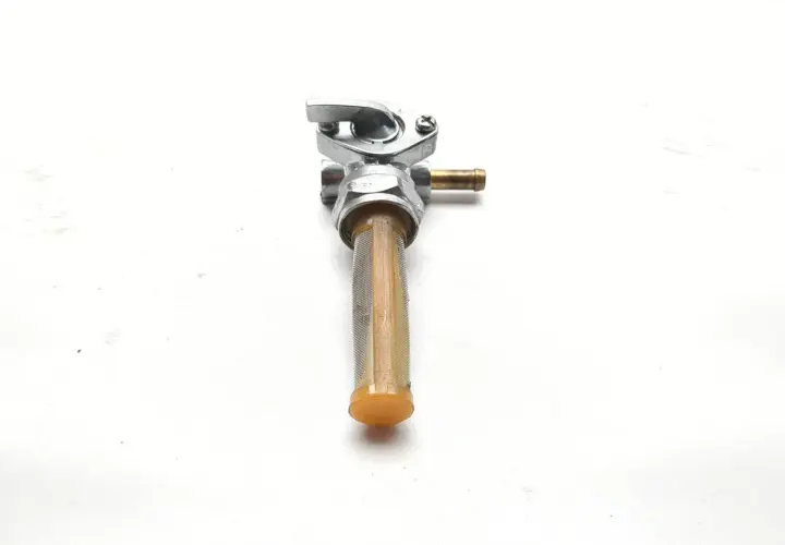 Llave de gasolina para moto con filtro. Permite controlar el flujo de combustible en sus posiciones llave.