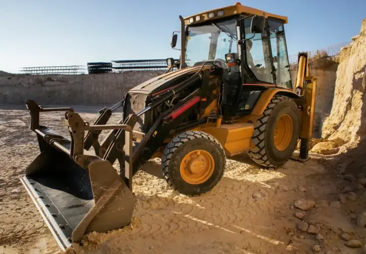 Żółta koparko-ładowarka JCB na budowie. Pytanie: jaki olej hydrauliczny do koparki jcb?
