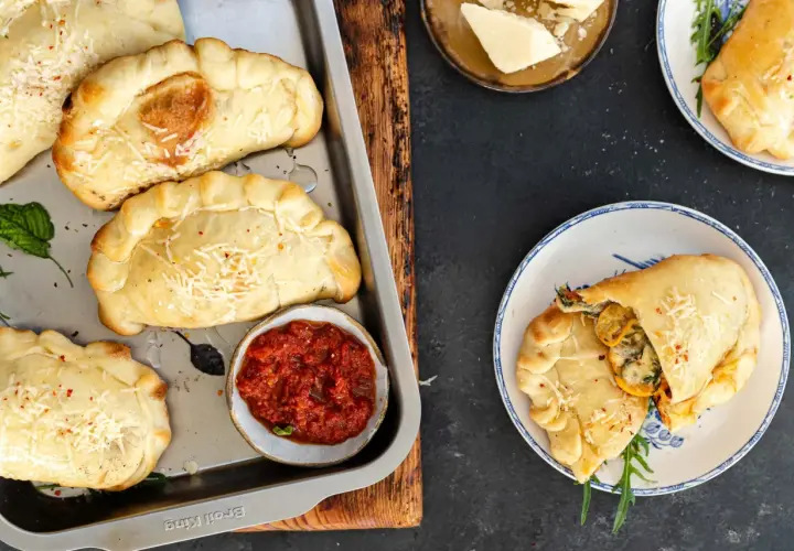Mini calzone przepis: złociste, pieczone pierożki z serem i ziołami, podane z sosem pomidorowym. Idealne na przekąskę.
