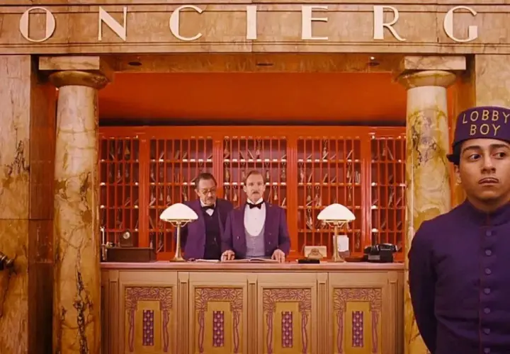 Lobby boy i dwaj recepcjoniści w hotelu, jak z filmów Wesa Andersona.
