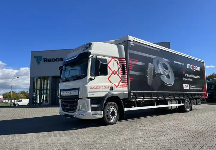 Biała ciężarówka DAF z naczepą reklamującą części samochodowe Maxgear. Długość tej ciężarówki to ok. 13,6 metra.