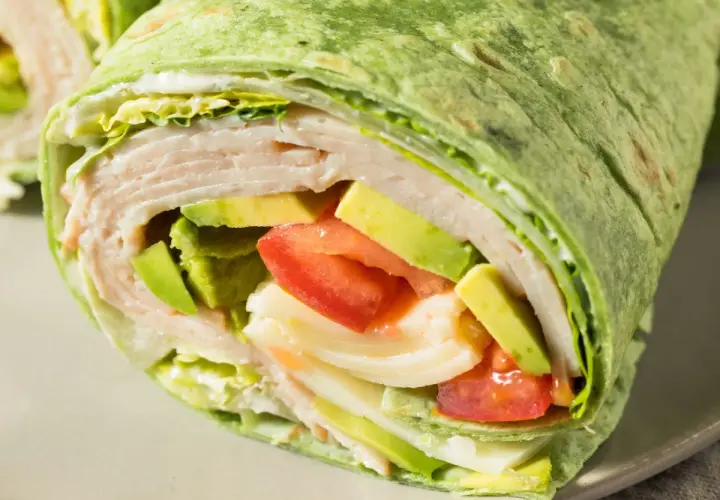 Zielona tortilla z cukinii wypełniona indykiem, awokado, pomidorem i sałatą. Pyszny i zdrowy wrap.