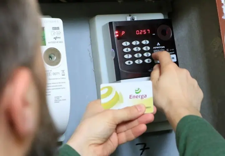 Doładowanie licznika przedpłatowego Energa. Osoba wprowadza kod na klawiaturze urządzenia.