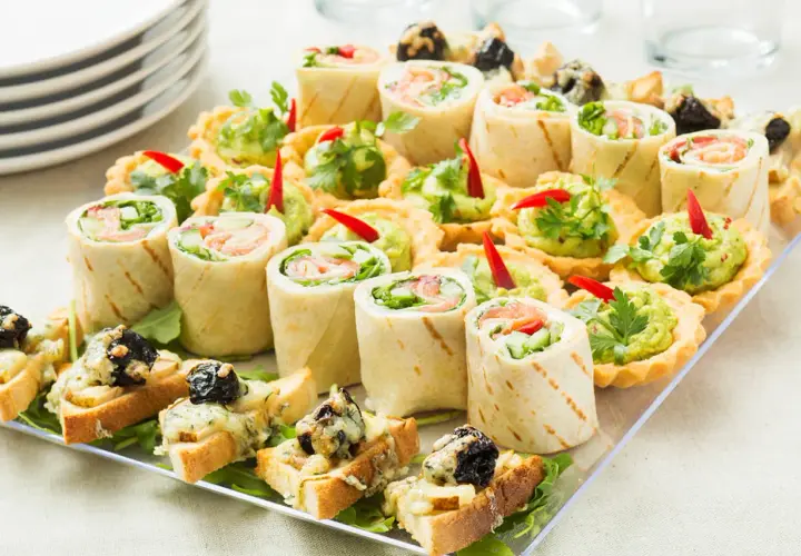 Patera na przystawki: rolki z łososiem, tartaletki z guacamole i grzanki z serem.