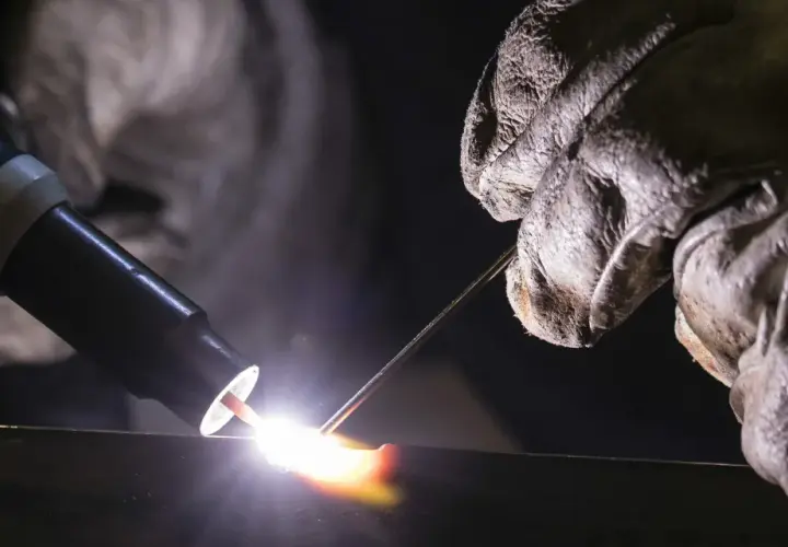 Un soldador usa una antorcha para crear una chispa brillante, demostrando que es la soldadura.