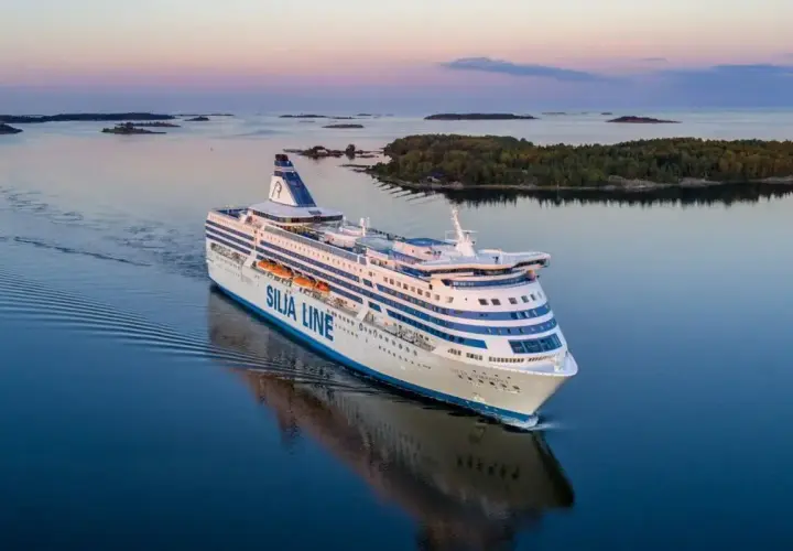 Prom Silja Line płynie przez spokojne morze, tworząc fale. Widok na wyspy i zachodzące słońce. Podróż z Tallinna do Helsinek.