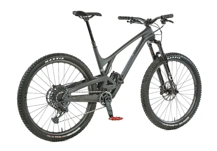 A dark grey Evil Offering mountain bike, ready for an evil offering review. Features Maxxis tires and red pedals.