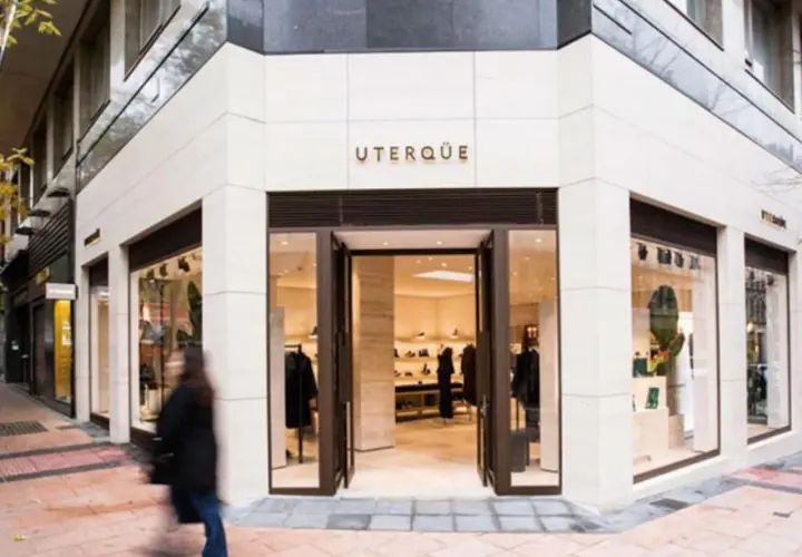 Fachada de tienda UTERQÜE con escaparates y entrada abierta. Una persona pasa por delante.