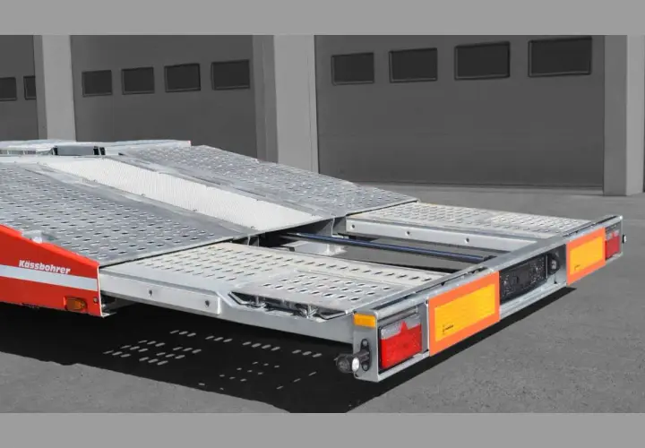 Ein roter Kässbohrer Autotransporter mit ausziehbarer Ladefläche, bereit für den Transport.