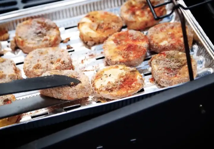 Oscypki w panierce smażone na grillu w aluminiowej tacce.