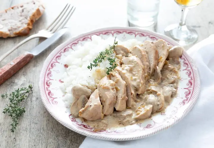 Délicieuse recette filet de poulet à la crème et champignons, servi avec du riz blanc et garni de thym frais.