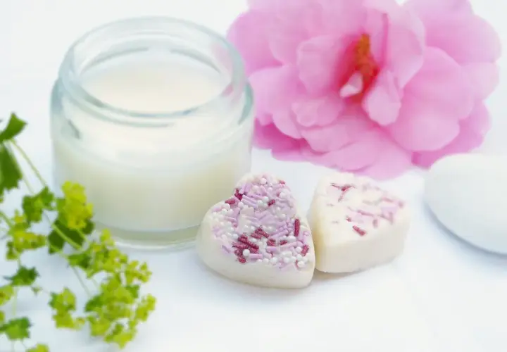 Słoiczek z kremem, serduszka z posypką i różowa piwonia. Krem zawiera caprylic capric triglyceride, składnik nawilżający.