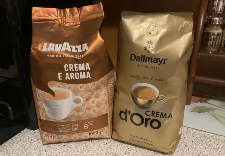 Dwie paczki kawy ziarnistej: Lavazza Crema e Aroma i Dallmayr d'Oro Crema. Idealne do przygotowania pysznego espresso, stanowią podstawę rankingu kaw ziarnistych.
