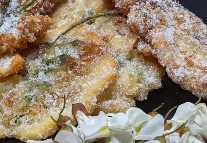 Délicieux beignets d'acacia, croustillants et saupoudrés de sucre, accompagnés de fleurs blanches.
