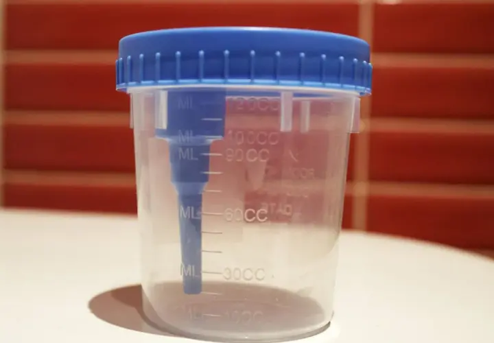 Contenitore sterile con tappo blu per la raccolta urine neonato, graduato per misurare il volume.