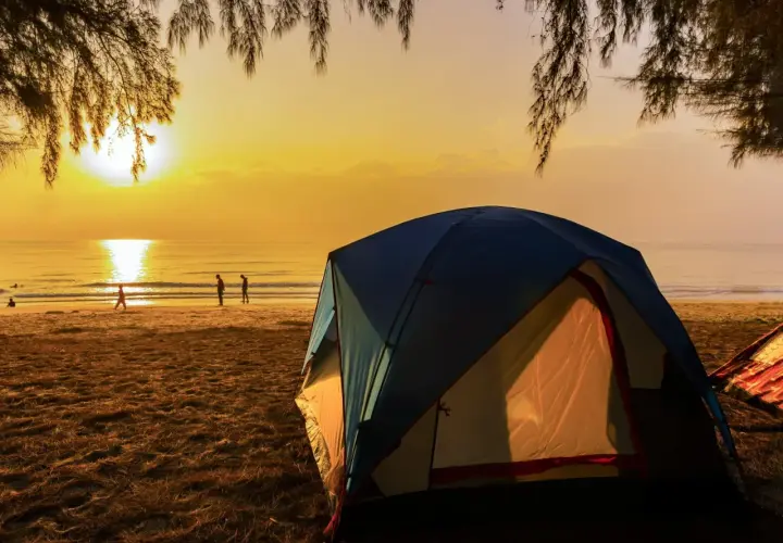 Namiot na plaży o zachodzie słońca. Idealne miejsce na tanie kempingi nad morzem, gdzie można podziwiać piękno natury.