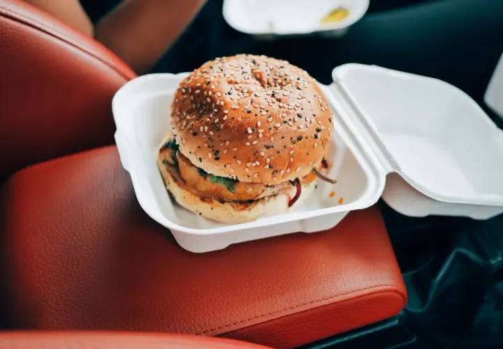 Pyszny burger w białym pudełku, idealny na szybki posiłek w podróży. Nie martw się o wieśmac kcal, ciesz się smakiem!