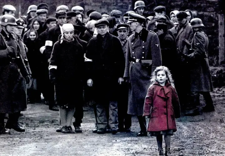 Dziewczynka w czerwonym płaszczu na tle sceny z filmu "Lista Schindlera" z obsadą.