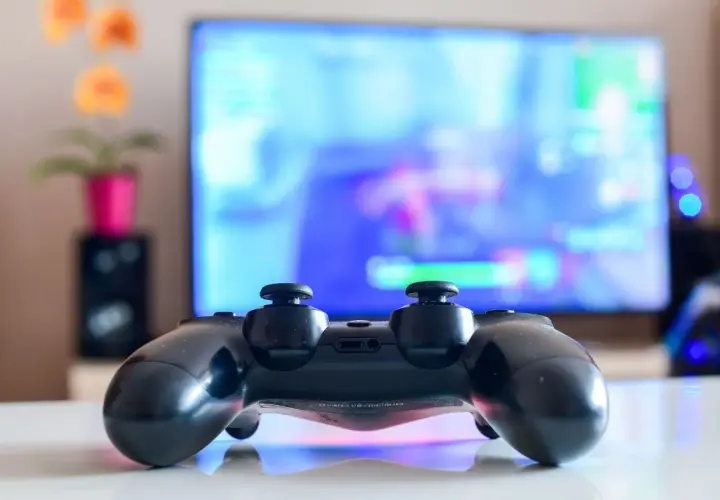 Czarny pad DualShock 4 na białym blacie, gotowy do gry na PC. Dowiedz się, jak podłączyć pada PS4 do PC, by cieszyć się grami na większym ekranie.