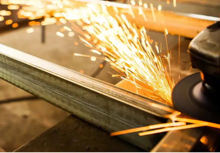Un disco da taglio genera scintille mentre taglia un profilo metallico. Ecco come tagliare alluminio con precisione.