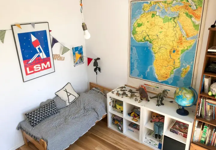 Pokój dziecka po metamorfozie: łóżko w paski, dinozaury i mapa Afryki.