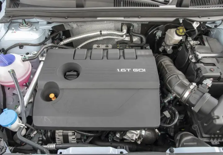 Silnik 1.6T GDI z widocznymi elementami osprzętu i płynów.