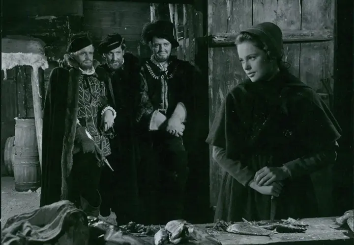 Scen från herr Arnes penningar film. En ung kvinna med kniv möter tre män i historiska dräkter.