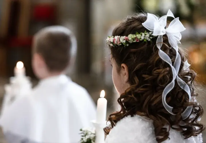 Dziewczynka z wiankiem i wstążkami we włosach trzyma świecę. Obok niej chłopiec. To ważny dzień, zastanawiasz się, ile trwa biały tydzień?