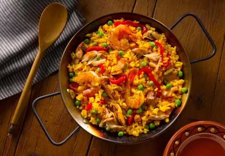 Paella de mariscos, un plato vibrante con arroz amarillo, gambas, mejillones y pimientos. ¡Así es como hacer paella!