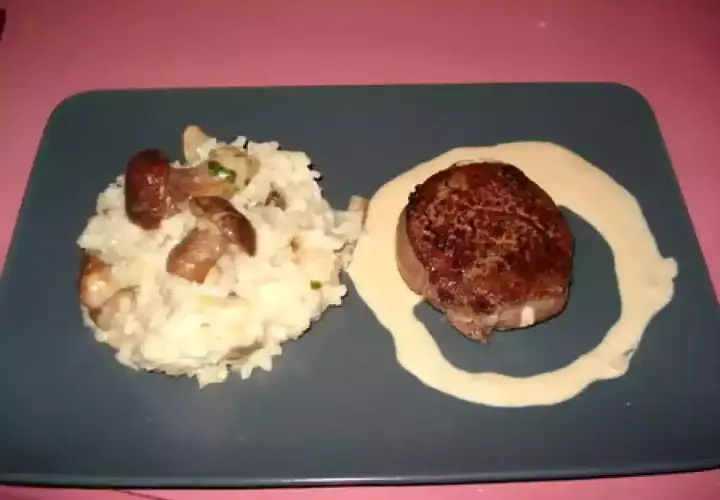 Un délicieux tournedos Rossini, un steak de bœuf tendre, servi avec un risotto crémeux aux champignons et une sauce onctueuse.