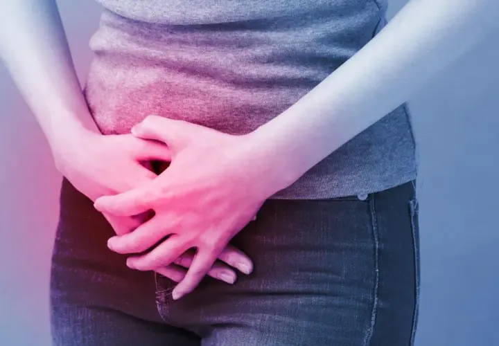 Osoba trzyma się za brzuch, odczuwając ból. Może to być objaw problemów, w leczeniu których pomaga Ditropan.