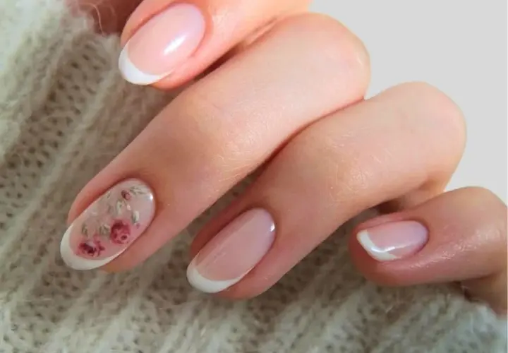 Delikatne paznokcie ślubne boho z subtelnym zdobieniem w postaci różowych kwiatów na jednym z paznokci. Klasyczny french manicure w nowoczesnym wydaniu.