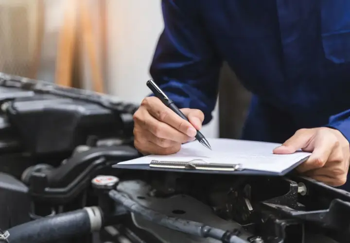 Mechanik spisuje protokół przeglądu, by uniknąć kary za spóźniony przegląd.