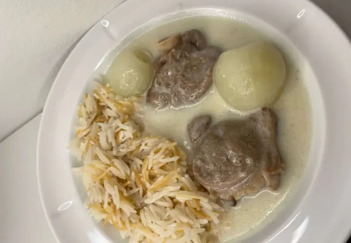 En tallrik med ris, köttbitar i en krämig sås och två hela kokta lökar. En riktig laban emo-måltid!
