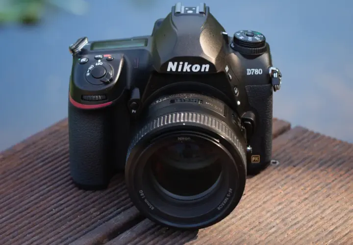 Nikon D780 z obiektywem 85mm f/1.8G na drewnianym pomoście. Aparat gotowy do testów.
