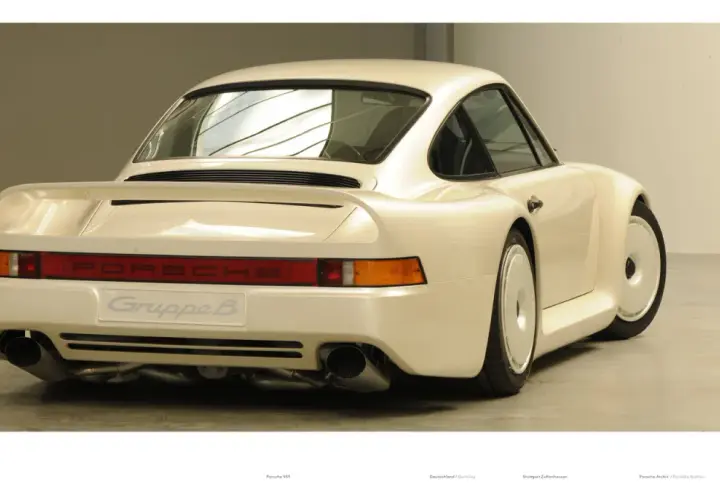 Biały Porsche 959 z napisem "Gruppe B" na tyle, prezentujący swoje charakterystyczne linie i podwójne końcówki wydechu.