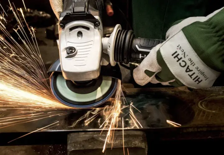 Rękawica Hitachi z tarczą szlifierską generuje iskry, pokazując siłę tarcia statycznego podczas pracy z metalem.