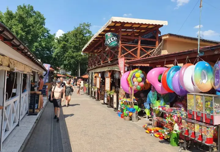 Skorzęcin atrakcje: kolorowe koła do pływania, zabawki i budki z grami na deptaku.